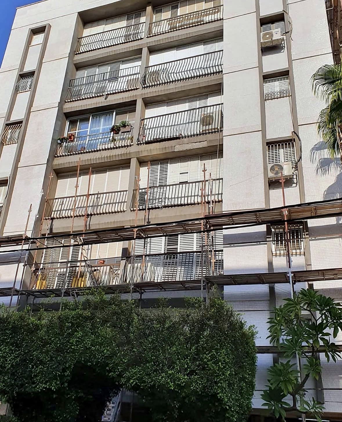חזית הבניין ברחוב גבעתי 8 בבת ים במהלך העבודה – פיגומים לאורך הקומות