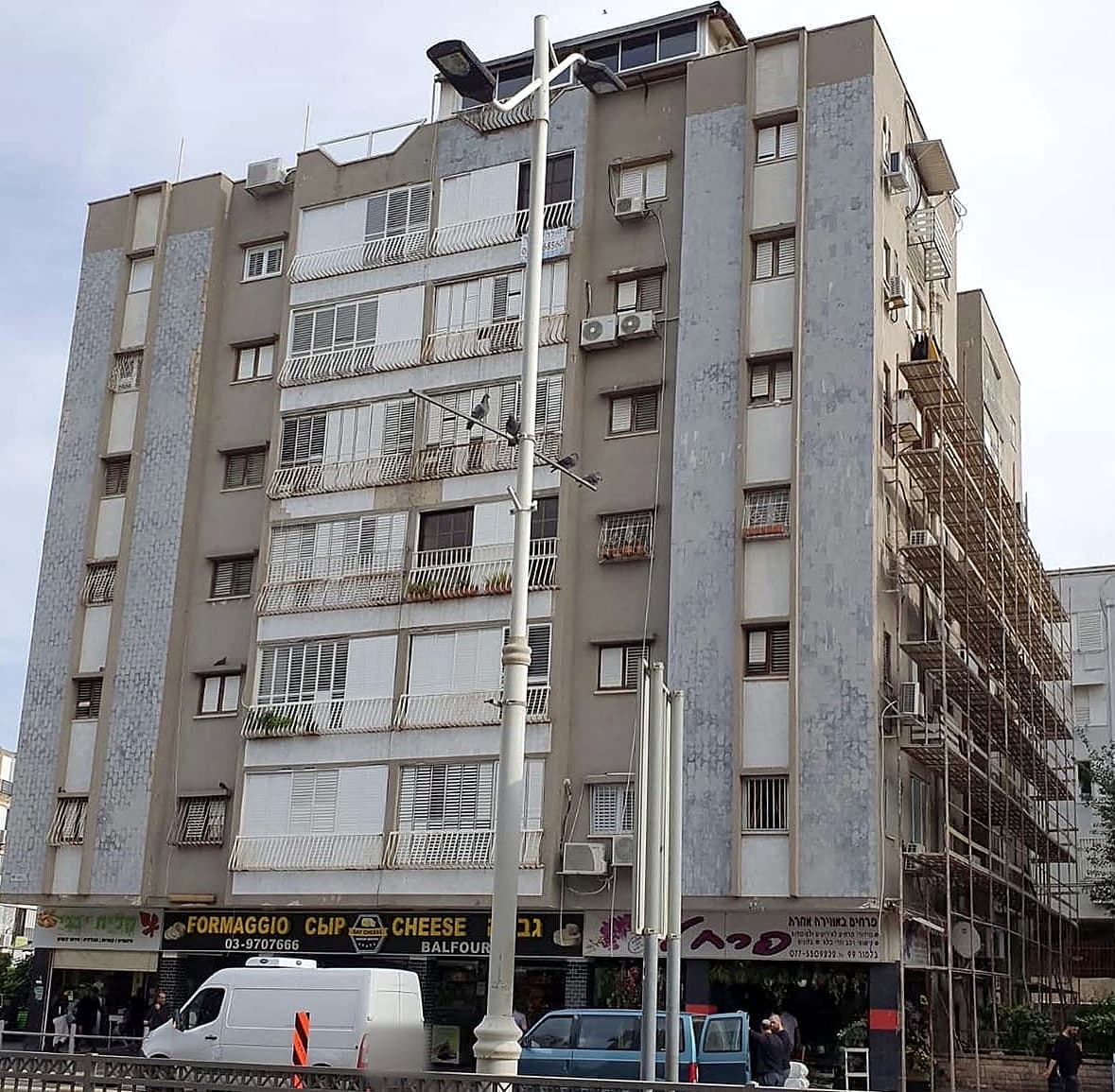 חזית הבניין ברחוב דנין 2 בבת ים לפני העבודה – חיפוי ישן ופיגומים בצד הבניין