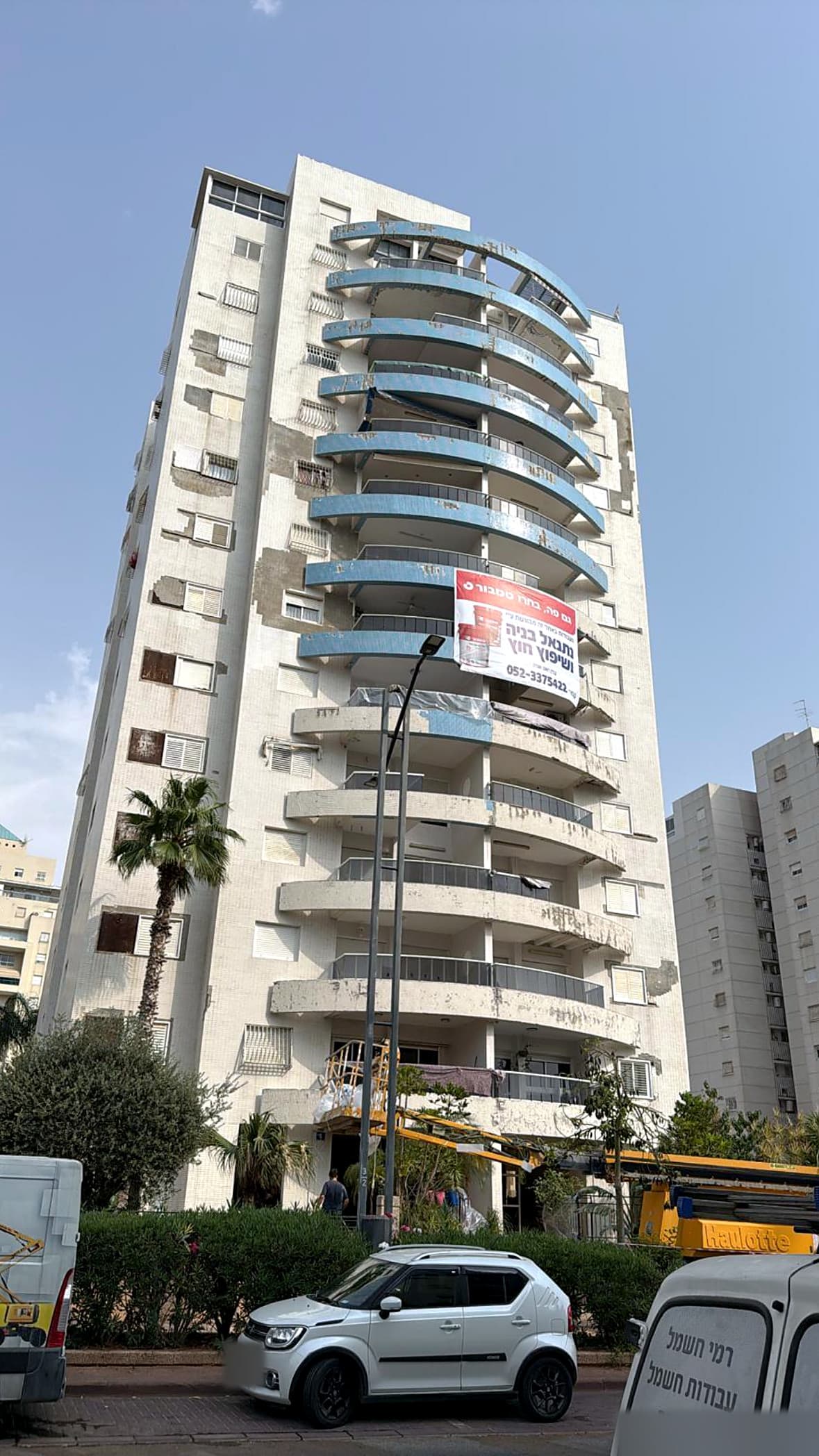 מגדל המגורים ברחוב התזמורת 4 בראשון לציון במהלך העבודה – במת הרמה והשלט שלנו על הבניין